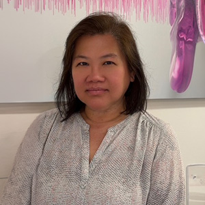 Pat Tang, Patient Care Coordinator at Manhattan Audio, smiling in the office.